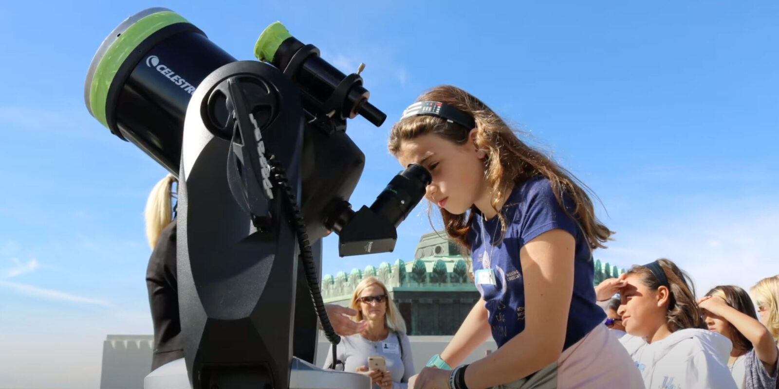 A girl looks through a telescope at Griffith Observatory.