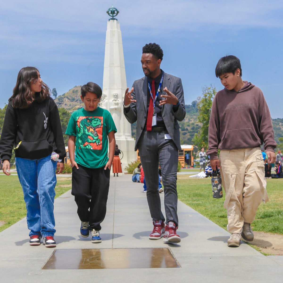 Museum Guide explains the planetary orbits on the front lawn to fifth graders.