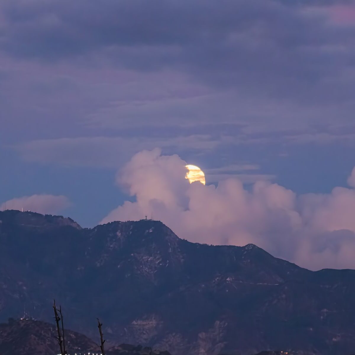 The moon rising above the clouds over San Gabriel mountains.
