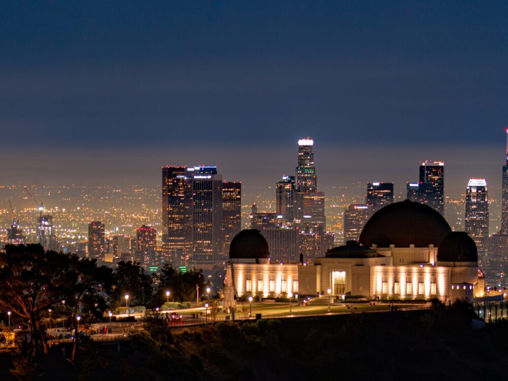 Griffith Observatory and Downtown Los Angeles glitter from a mountain trail on a clear night.