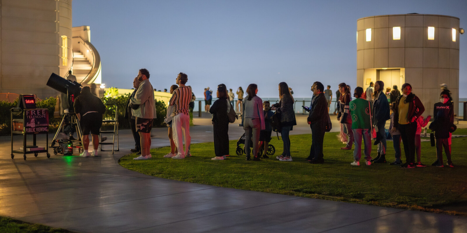 Patrons wait in line to look through a lawn telescope.